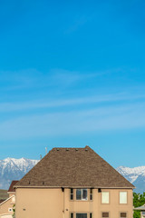 House exterior with blue sky and snow capped mountain background on a sunny day