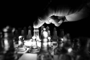 The concept of business competition: Close-up of a businessman holding a glass chess