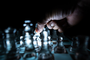 The concept of business competition: Close-up of a businessman holding a glass chess