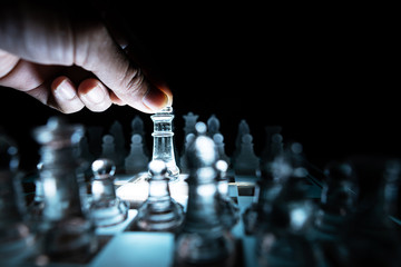 The concept of business competition: Close-up of a businessman holding a glass chess