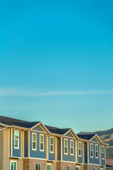 Townhomes exterior with blue sky and mountain background on a sunny day