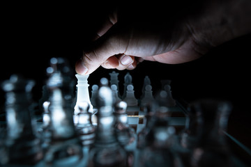 The concept of business competition: Close-up of a businessman holding a glass chess