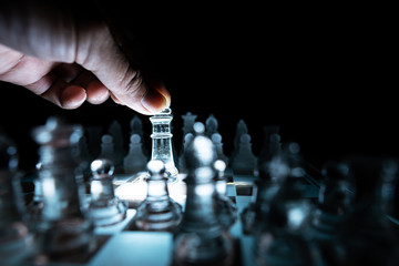 The concept of business competition: Close-up of a businessman holding a glass chess