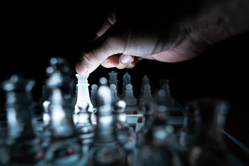 The concept of business competition: Close-up of a businessman holding a glass chess
