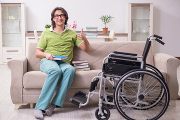 Young male student in wheelchair at home