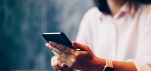 woman holding a smartphone, mock up of blank screen. using cell phone on cafe. Technology for communication concept.