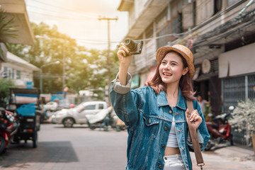 Smiling traveler backpack woman shooting camera. Walking street.