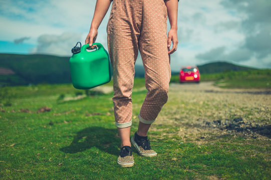 Young woman with can of gas in the wilderness