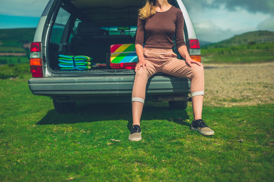 Young woman resting in the trunk of her car