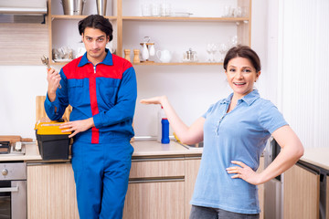 Young male repairman repairing tap