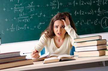 Young female math teacher in front of chalkboard