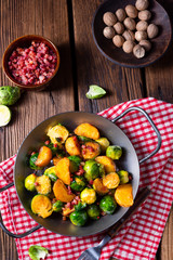 Brussels sprouts potato pan with bacon in rustic style