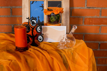 Halloween home decorations with spiders and pumpkin bucket for trick or treat. Greeting Card. Halloween pumpkin brick background. Happy Halloween picture. Ideas for Halloween. Indoor decoration.