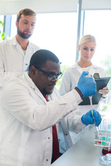 Scientist and students working in lab. Doctor teaching interns to make blood analyzing research....
