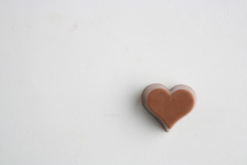 Chocolate bonbon with heart shape on white background