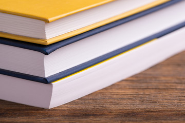 Books lie on top of each other. Books close up. A stack of books lying on a wooden table.