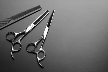 Hairdresser tool. Barber scissors and comb on a dark background.
