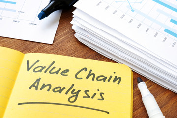 Value chain analysis sign and stack of documents.