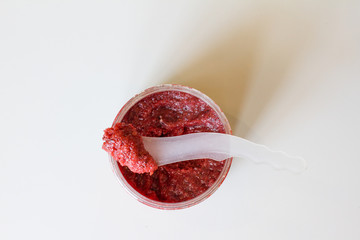 red body scrub made of natural salt. jar with makeup on white background. the view from the top. body care. Spa treatment at home and beauty salon.