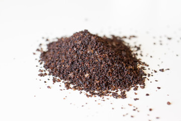 brown body scrub, on white background. Coffee scrub against cellulite. the view from the top. Sample of natural scrub. Small coffee beans. Ground caffeine.