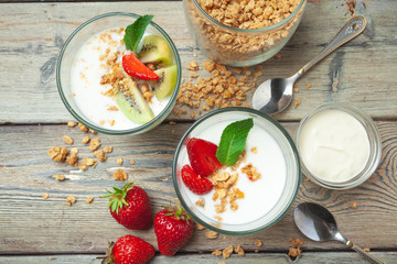 Healthy breakfast with yogurt, berries and granola on wooden table top view