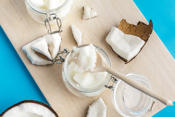 Coconut pieces on wooden board on blue background
