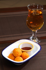 Fried balls of cheese. Cheese balls fried in breadcrumbs with sauce and wine. Deep Fried Breaded Cheese.