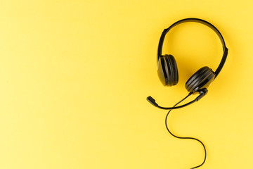 Customer service headset on yellow background. Call center concept