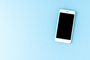 Smartphone with empty screen on blue desktop. Top view