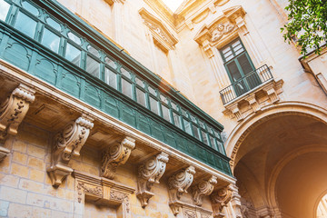 Malta's long large green traditional style balconies and arch in the building.