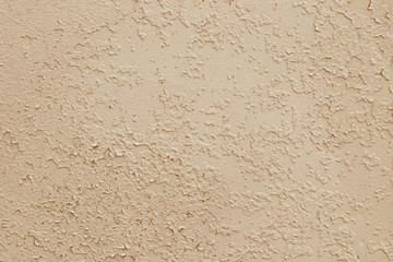 Yellow texture of peeling paint, light brown background. Dirty concrete wall. Retro effect. Empty space. Abstract beige pattern, damaged surface. Cracks, grunge rough stucco. Old metal door.