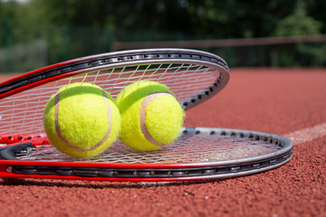 Two tennis balls resting on top of tennis racquet