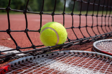 Tennis scene with black net, ball and racquets