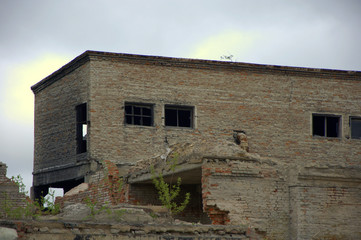 Old dilapidated brick building on the background of an old factory.