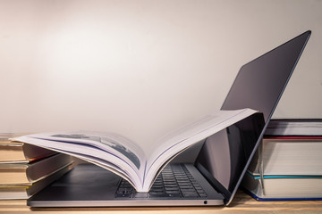 World Information day - books, open computer with open book are on the wooden table on the white...
