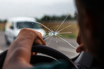 Broken windshield of a car. A web of radial splits, cracks on the triplex windshield. Broken car...