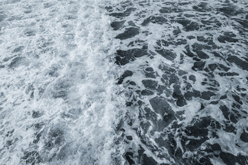 Organic background of dark blue aqua sea water surface splashing outside. Horizontal color photography.