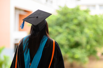 Portraits on the back of the graduates wearing a black ruffle dress at the university.
