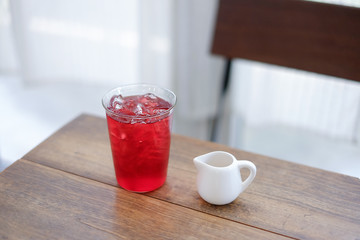 A glass of rose ice tea with syrub , relaxing drink on wooden table.  selective focus.