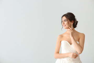 Beautiful young bride on light background