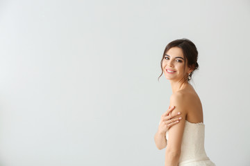 Fototapeta premium Beautiful young bride on light background