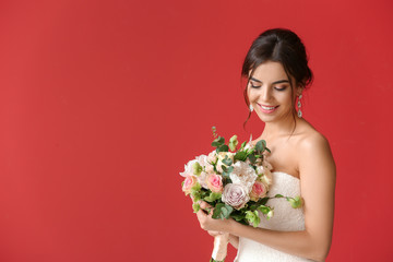 Beautiful young bride with bouquet of flowers on color background