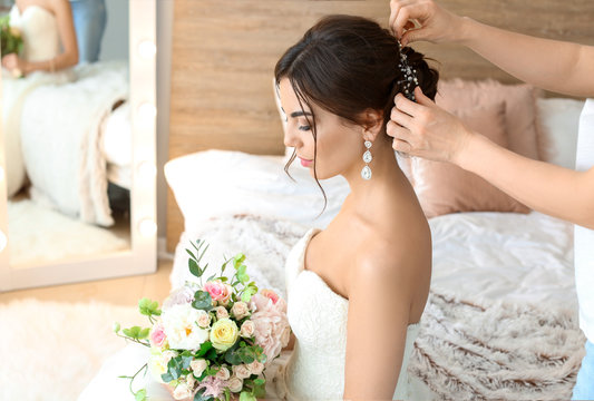 Professional hairdresser working with young bride at home