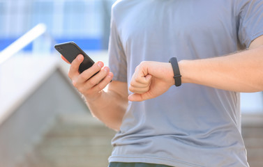 Sporty young man checking his pulse outdoors