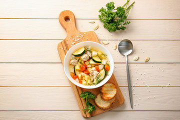 Bowl of tasty soup on wooden table