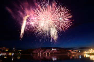 Beautiful pyrotechnic fireworks at night over the water. Celebration.