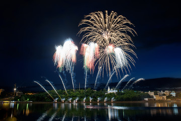 Beautiful pyrotechnic fireworks at night over the water. Celebration.