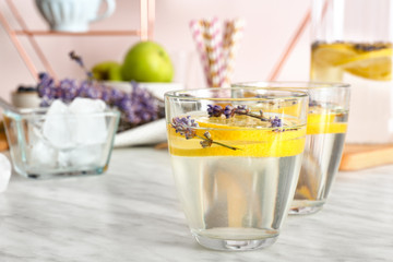 Glasses of tasty infused water on light table