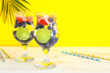 Glasses of tasty infused water on light table