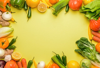 Frame made of fresh vegetables on color background
